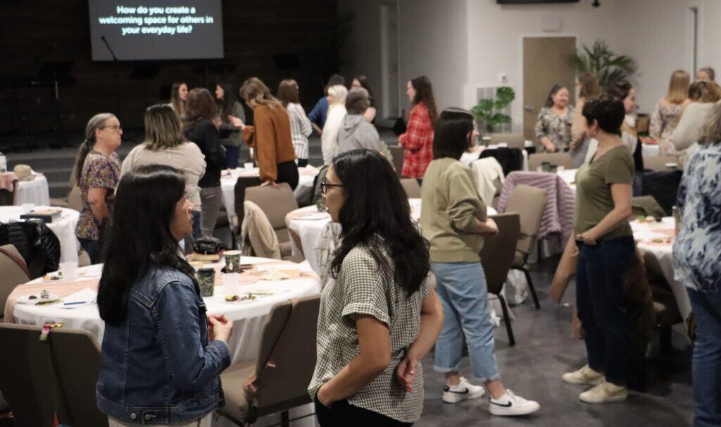 Women from Risen Hope Church in Summerville, SC stand around circular tables talking